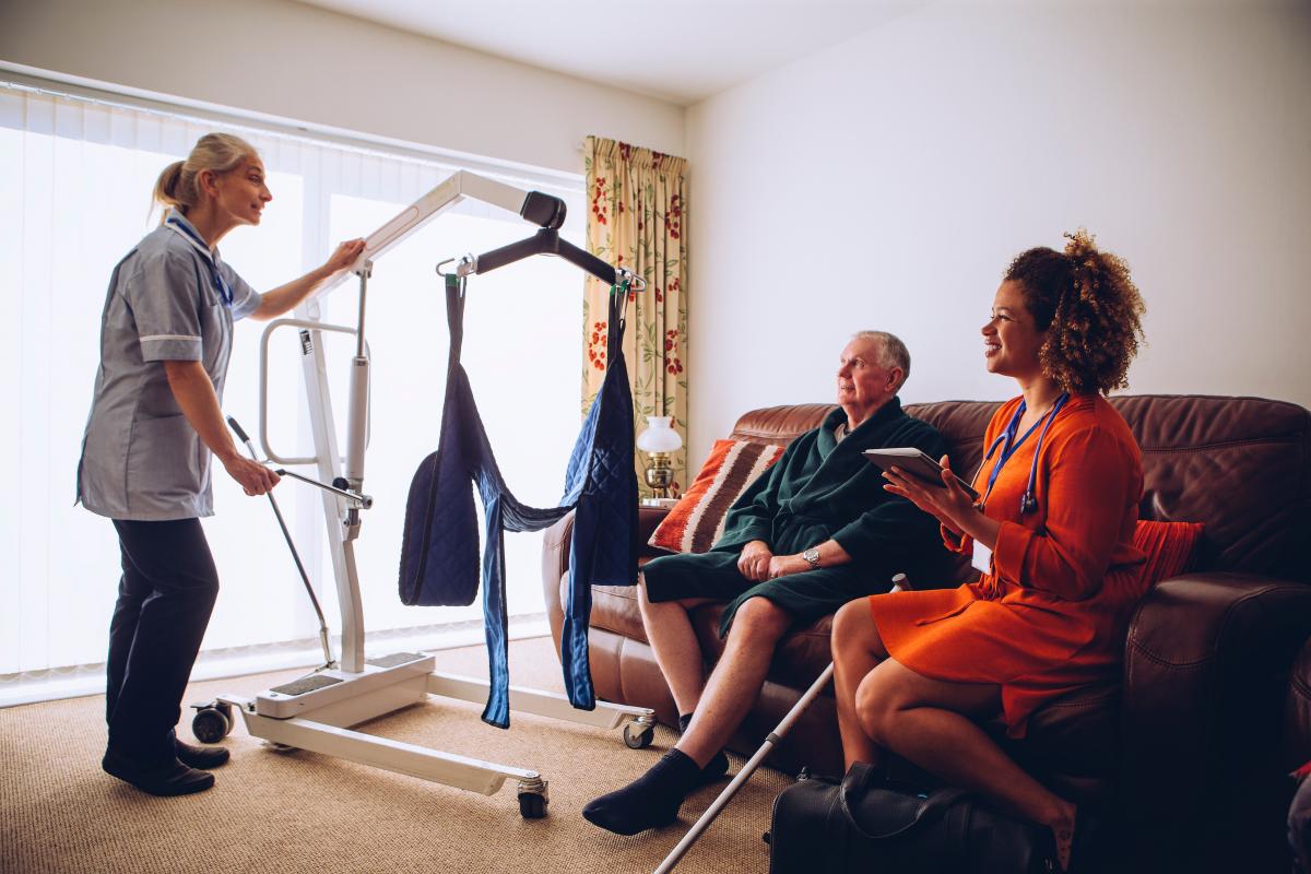 Mobile hoist with sling attached operated by a support worker