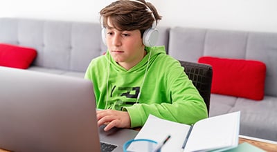 Boy with ADHD in front of computer with tutor