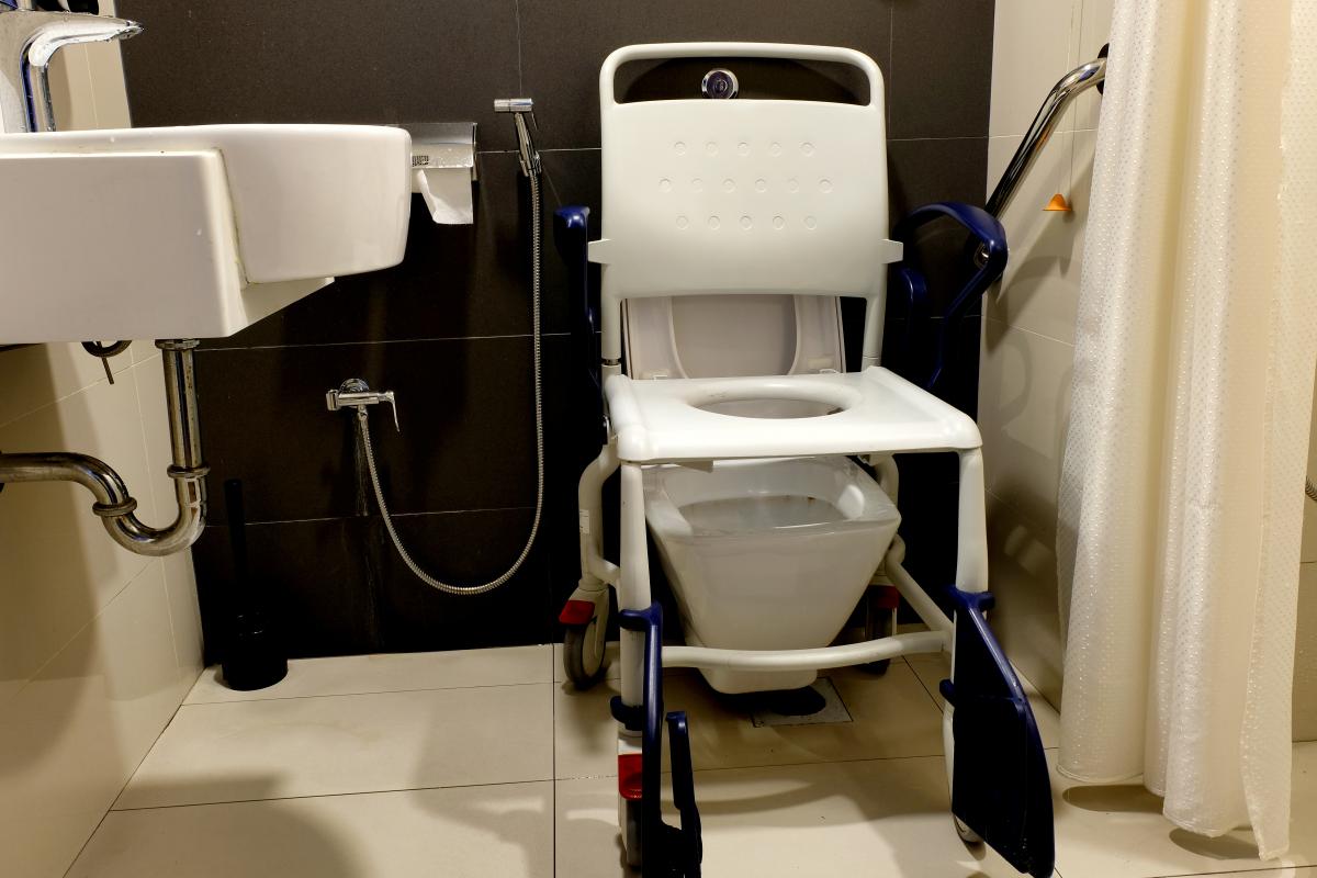 mobile shower commode positioned over toilet