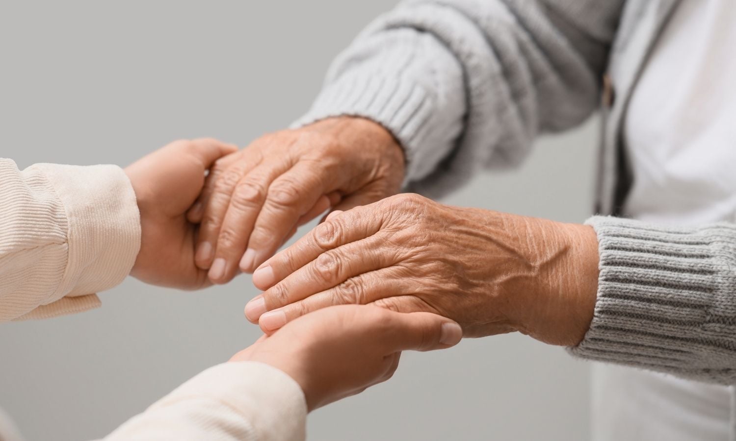 carer holding elderly person's hands in aged care