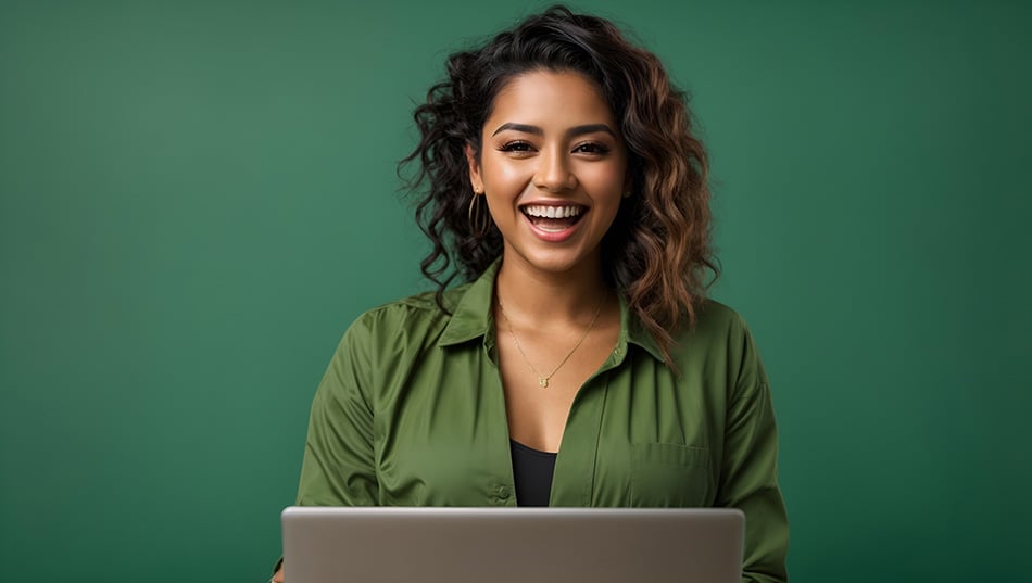 A happy young woman sitting at a laptop