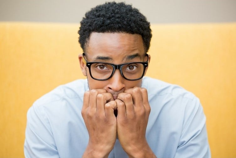 Man biting nails looking anxious