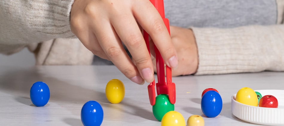 Person picking up beads in an therapy session