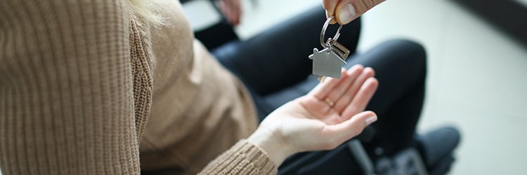 Woman sitting in a wheelchari about to get a set of house keys