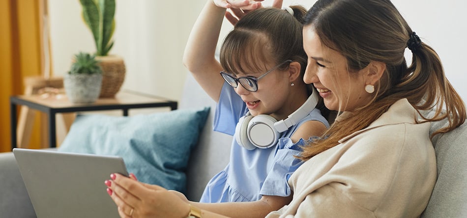 A mum and child interacting with a computer screen during teletherapy