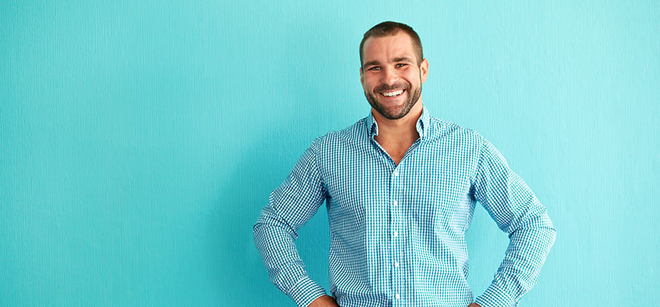 Man standing smiling with his hands on his hips
