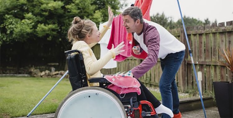 Carer with young girl in wheelchair