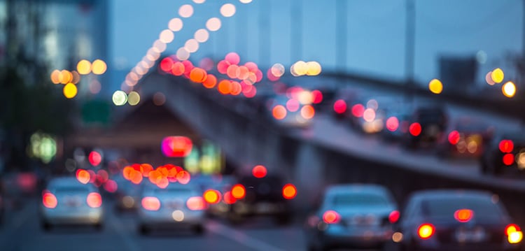 an out of focus picture of cars travelling on a highway, their red brake lights shining
