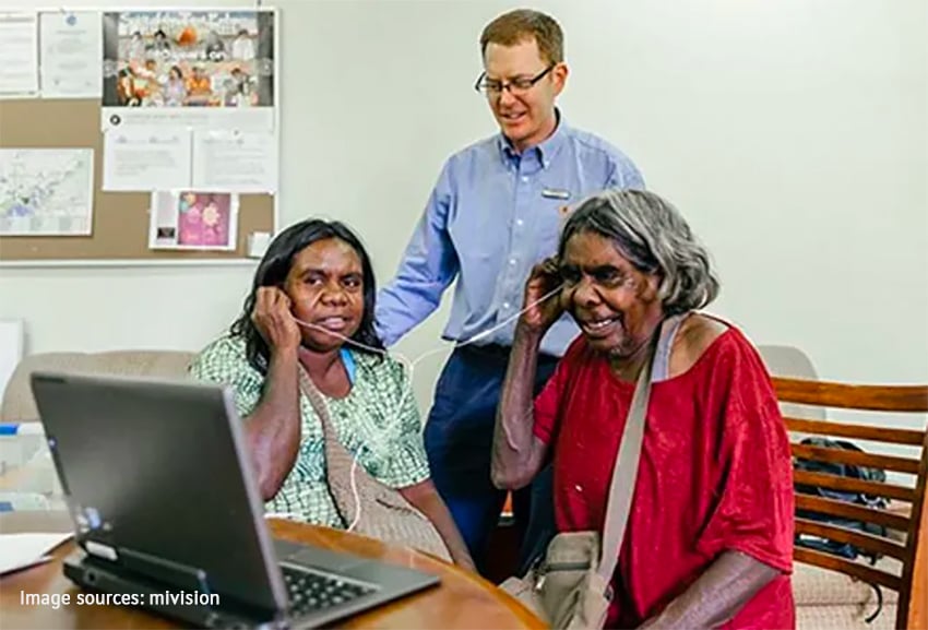 Aboriginal people sharing headphones watching laptop screen
